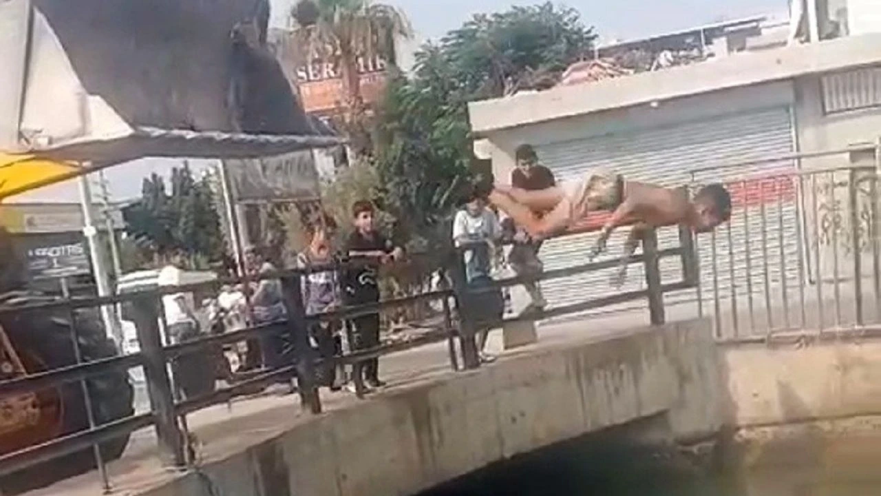 Adana'da çocuklar iş makinesinden sulama kanalına atlayarak serinlemeye çalışıyor!
