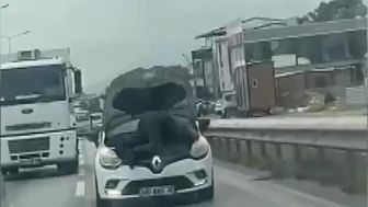 Bursa'da kaputu açık otomobilin motorunun üzerinde yolculuk yaptı