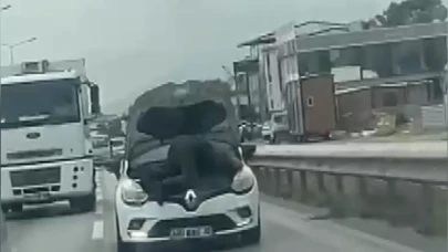 Bursa'da kaputu açık otomobilin motorunun üzerinde yolculuk yaptı