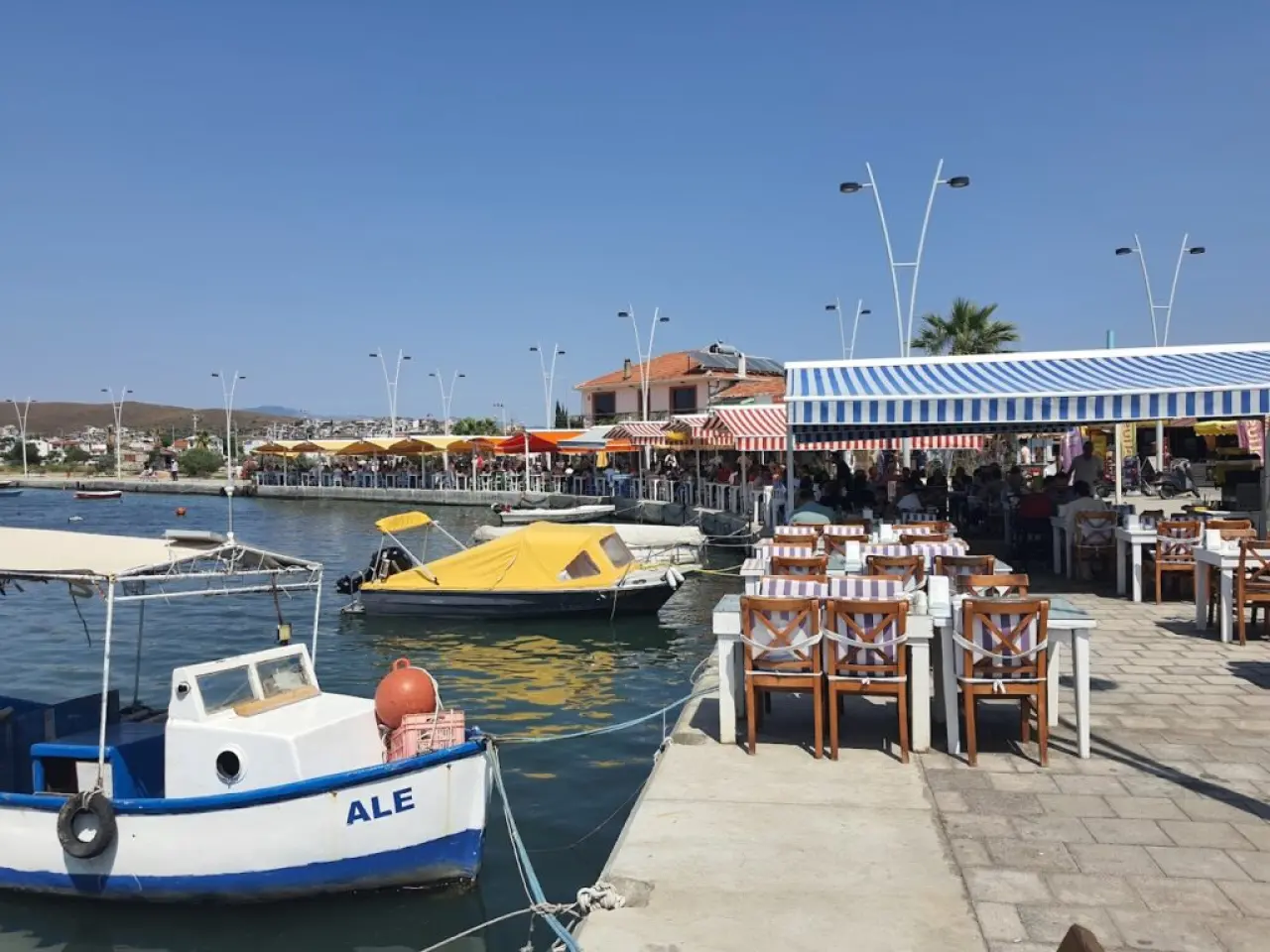 Denize sıfır park edilmiş karavan ve sabah kahvesi içen kampçı