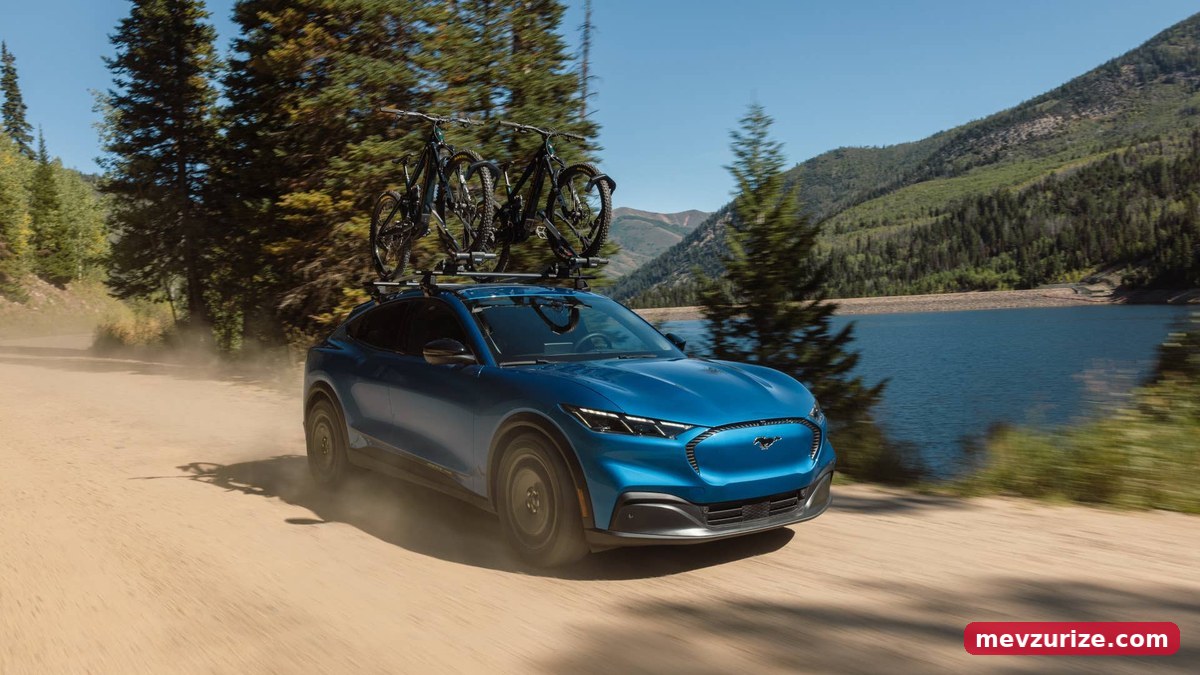 Thule tavan çıtası kitine bağlı bisikletlerle toprak yolda ilerleyen Mustang Mach-E Trail (Ford)